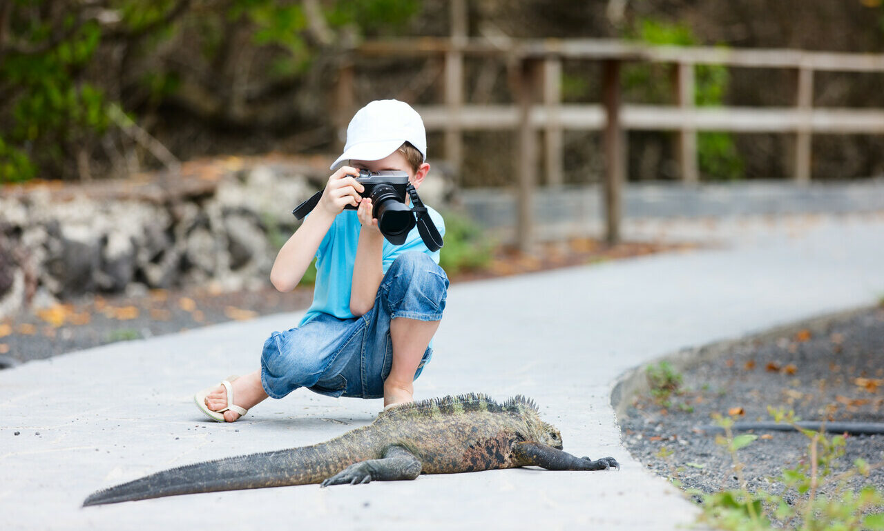 criança-fotografando-iguana-marinha-em-Galapagos